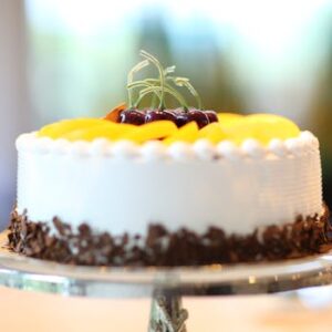 Elegant cake with fruits and chocolate shavings, perfect for celebrations.