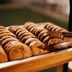 Close-up of freshly baked chocolate chip cookies on a wooden tray, indoors.