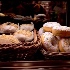 A tempting display of donuts and pastries in wicker baskets at a bakery. Perfect for food lovers.