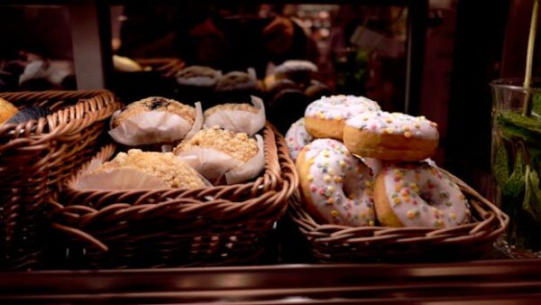 A tempting display of donuts and pastries in wicker baskets at a bakery. Perfect for food lovers.