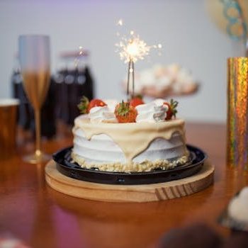 A festive birthday scene with a cake and sparkler on a decorated table, capturing the essence of celebration.