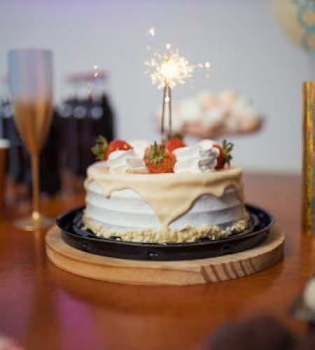 A festive birthday scene with a cake and sparkler on a decorated table, capturing the essence of celebration.